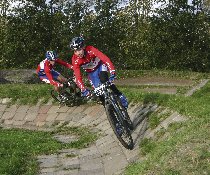 Twee sporters mountainbiken op het parcours